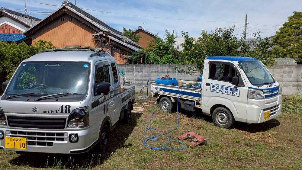 広陵町の農園での井戸工事が完了し、現場に駐車されたホウワの軽トラック2台