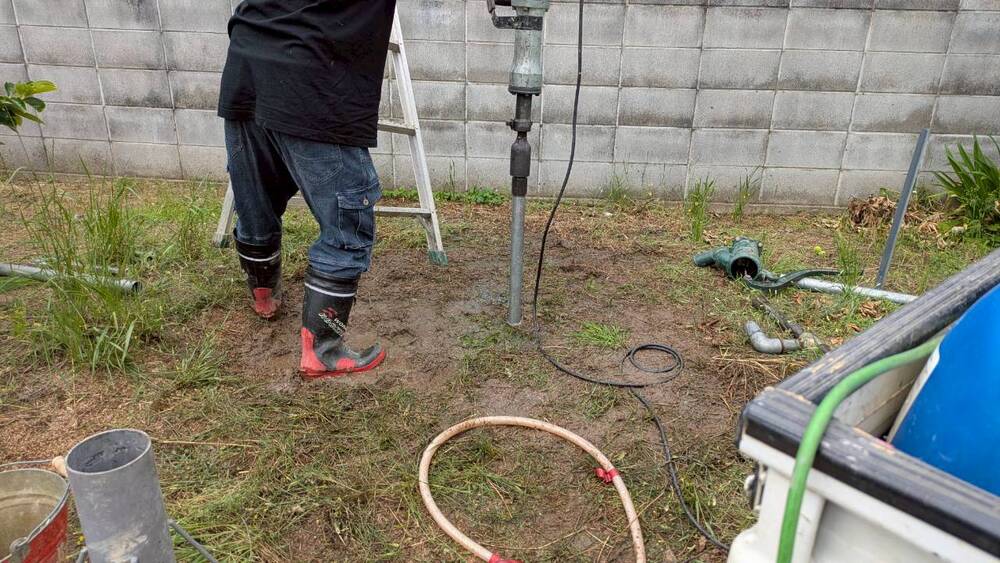 地面から泥が滲み出る中、水脈を目指して確実な掘削を進める様子