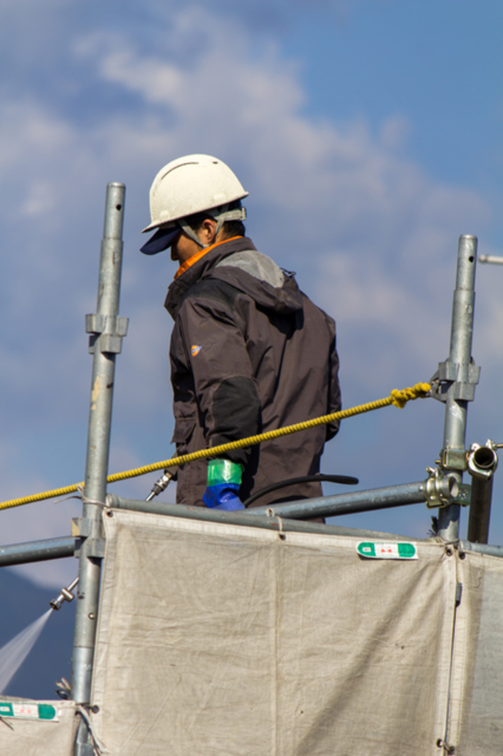 解体工事中の粉塵飛散を徹底的に防ぐため、丁寧に散水作業を行うホウワの熟練スタッフ