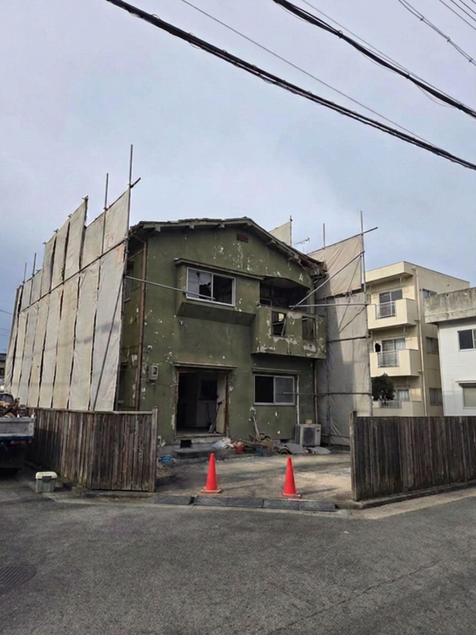 吹田市の住宅密集地における解体工事前の丁寧な防音・防塵シート養生風景