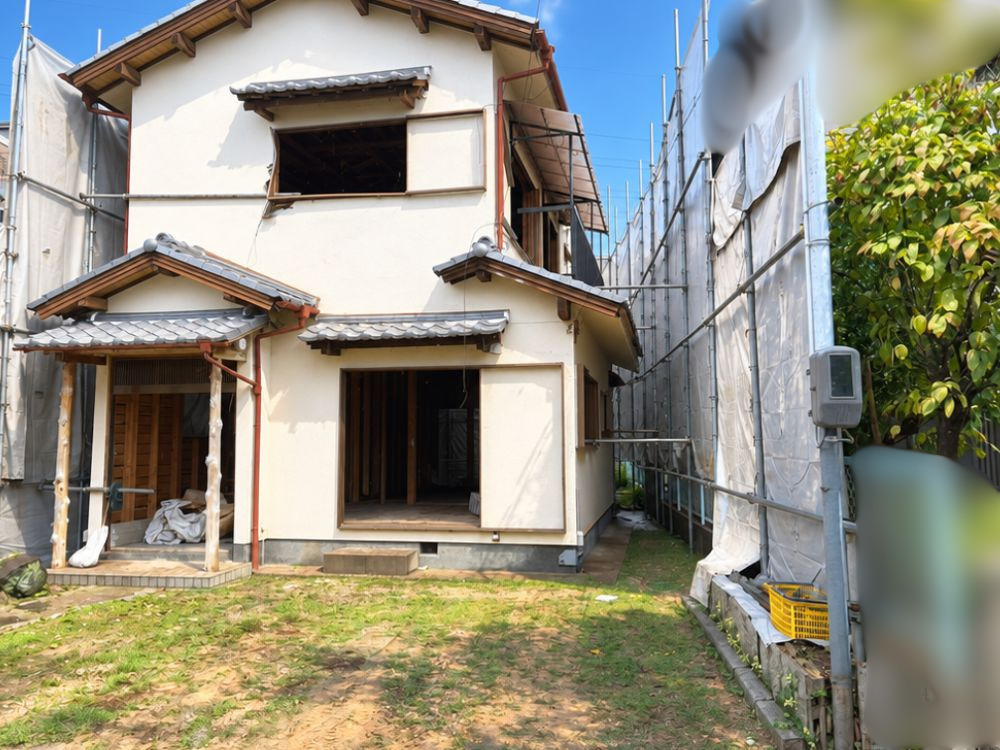 奈良県葛城市での木造2階建て住宅（28坪）の解体工事着工前の様子。足場と養生シートが組まれ、内部撤去や解体準備が進む2階建て家屋。